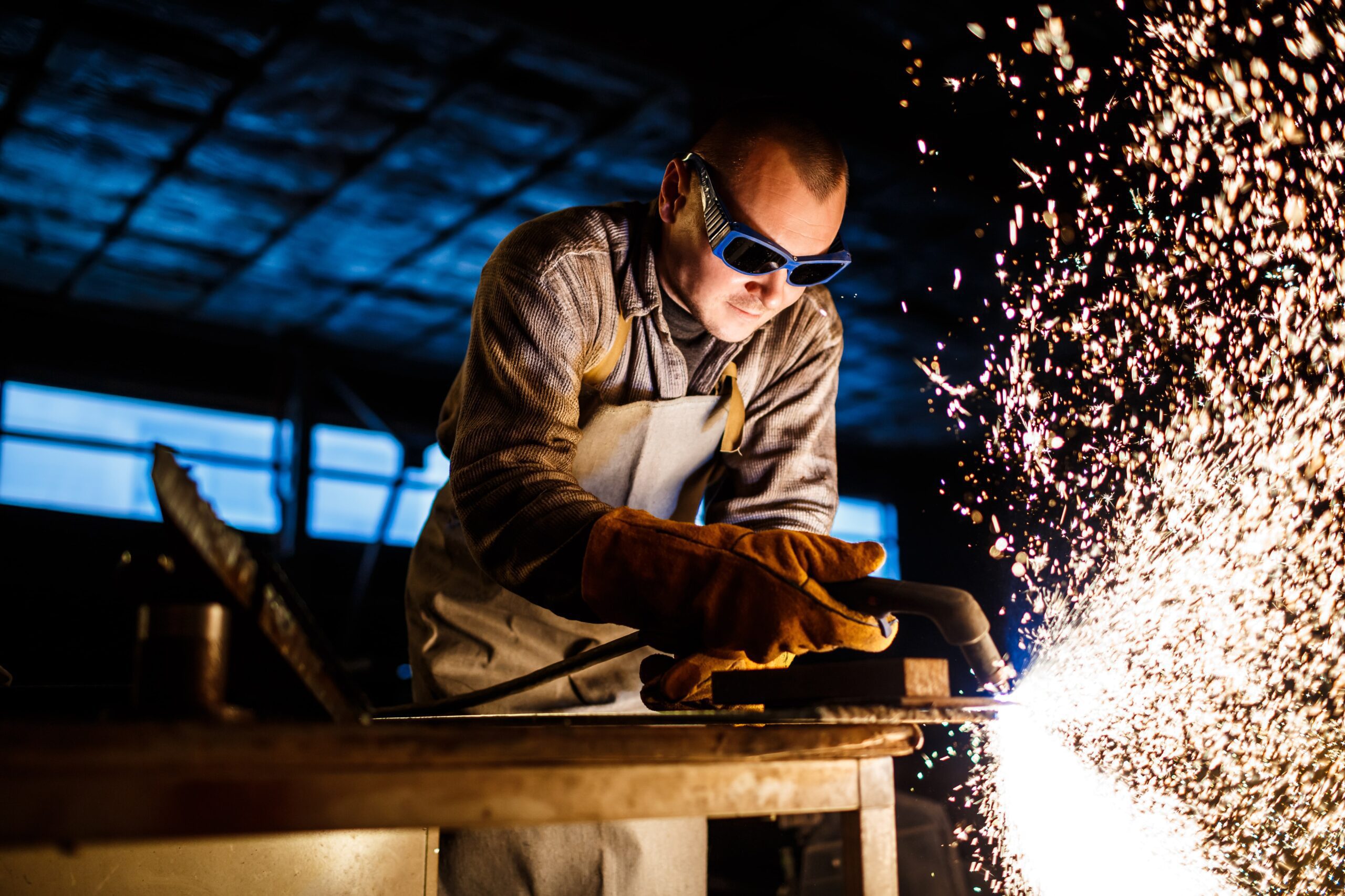 A welder working on a piece of metal causing sparks
