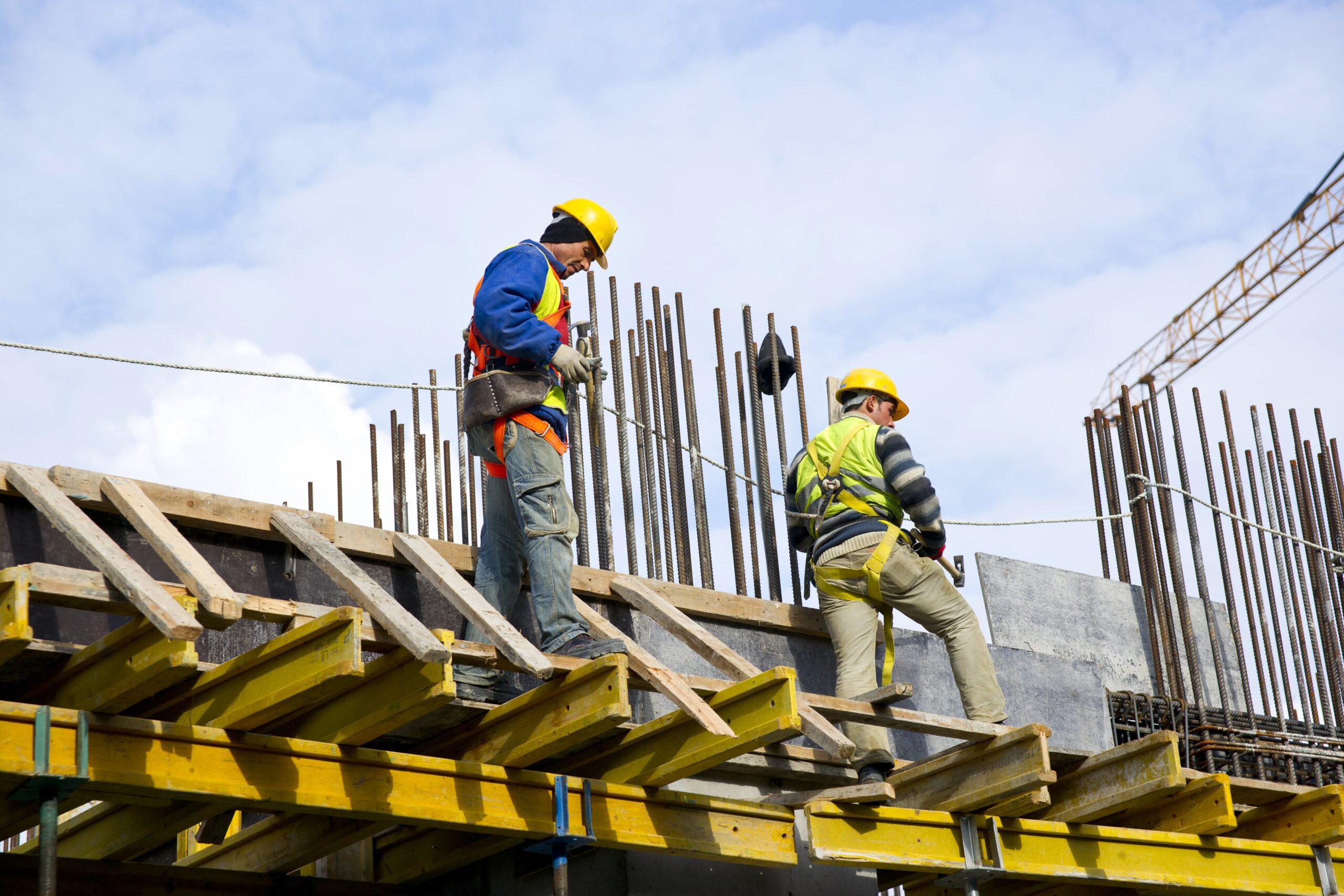 two construction workers stand on a concrete mold ready for the pour