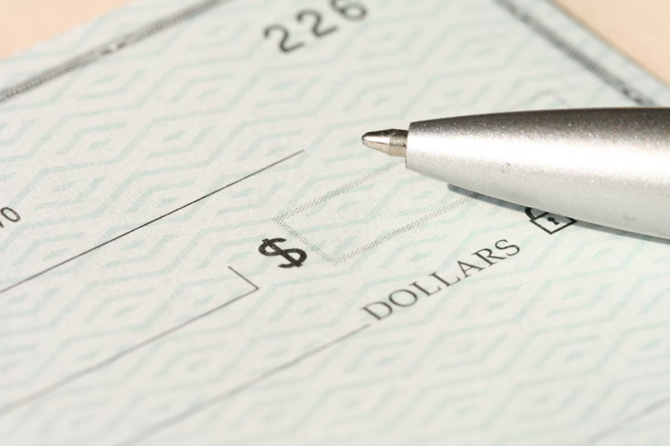 A pen over a blank check